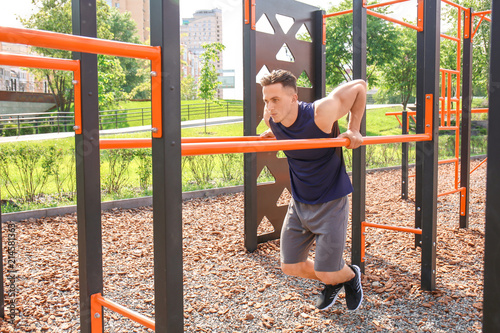 Sporty young man training on athletic field