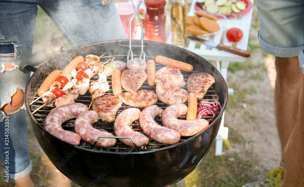 Woman preparing meat and vegetables on modern grill outdoors Woman preparing meat and vegetables on modern grill outdoors