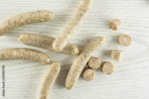 Lot of whole lot of slices of bavarian white sausage stack flatlay on grey wood photo