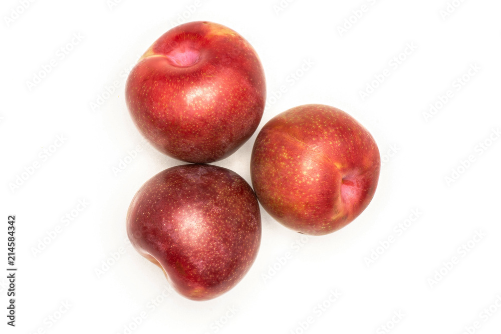 Group of three whole fresh pluot interspecific plums variety flatlay isolated on white Group of three whole fresh pluot interspecific plums variety flatlay isolated on white
