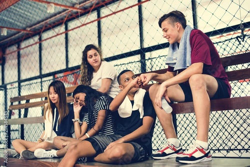 Group of young teenager friends sitting on a bench relaxing