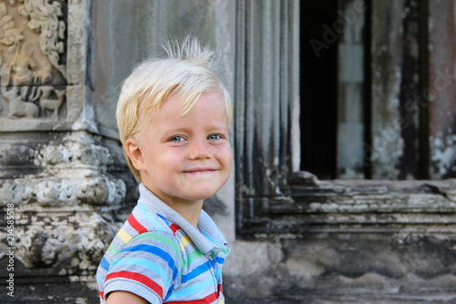 Cute little boy 4 years old blond hair sitting outdoor photo