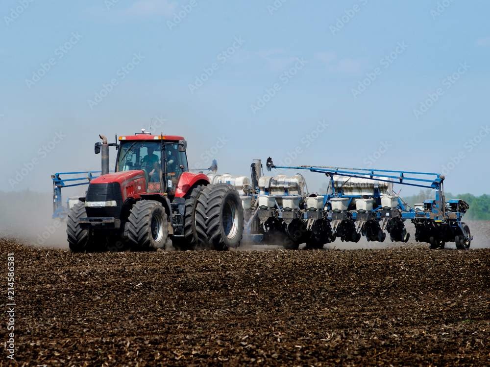 Fototapeta premium Tractor sowing the corn on the field