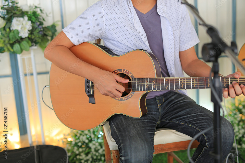 Obraz premium Close-up musician playing acoustic guitar in the cafe shop.