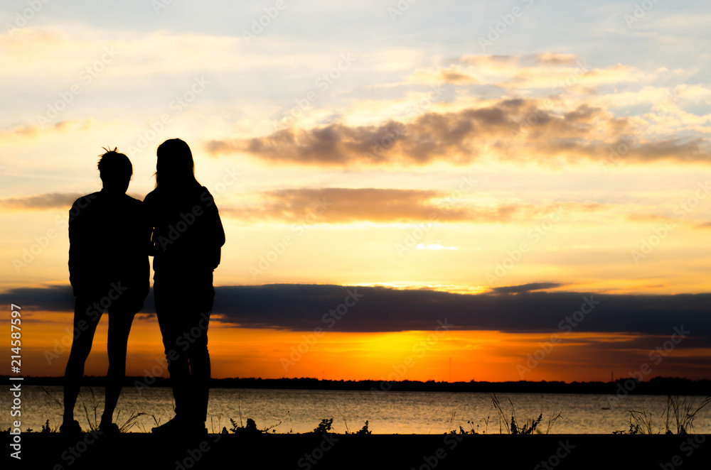 Couple woman silhouette standing very happily talking during sunset and beautiful sky.