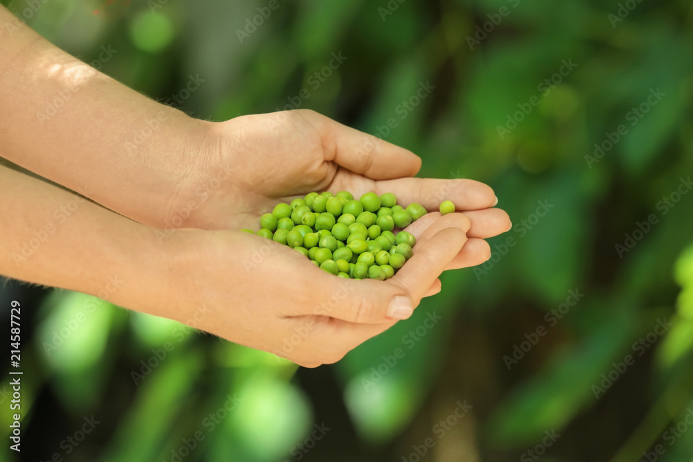 Young woman holding fresh green peas outdoors, closeup Young woman holding fresh green peas outdoors, closeup