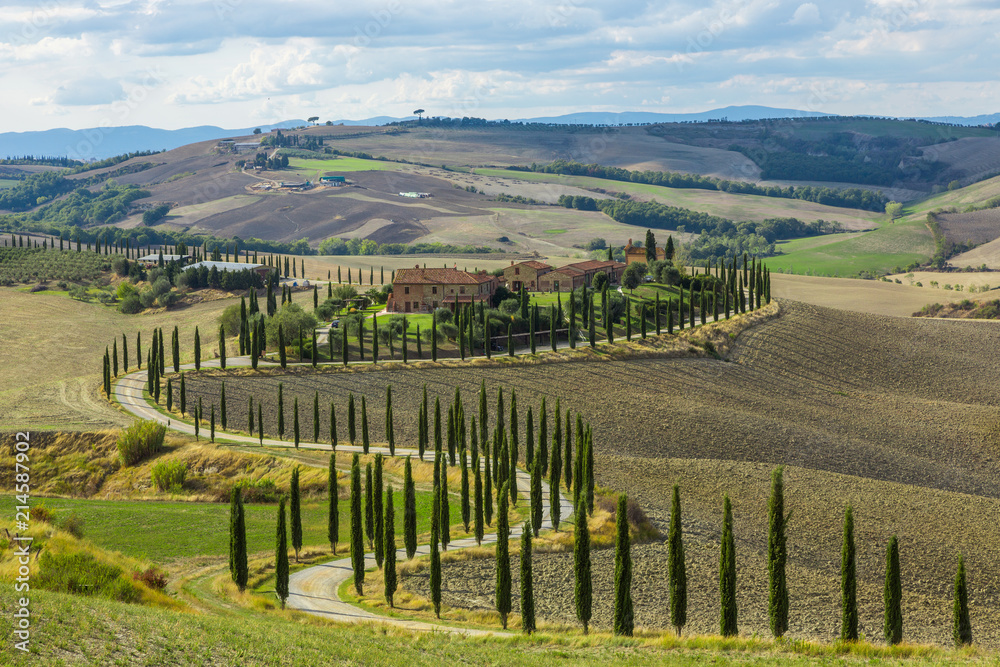 ITALY, TUSCANA - OCTOBER 8, 2017: Landscape of hills, country road, cypresses trees and rural houses,Tuscany , rural Italy