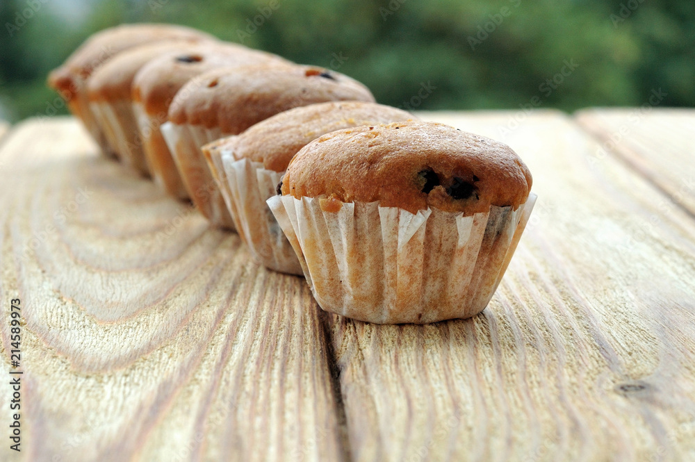 Muffins in a row on a wooden background Muffins in a row on a wooden background