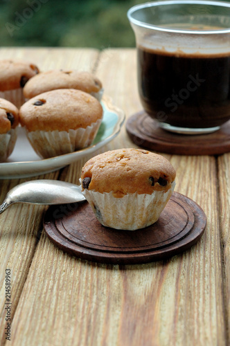 Muffins and a cup of coffee on a wooden background