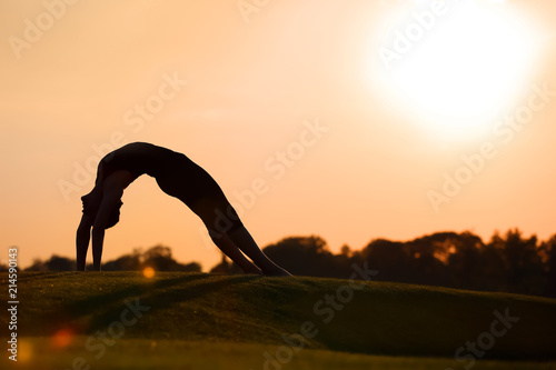 Fototapeta Naklejka Na Ścianę i Meble -  Beautiful young woman practicing yoga outdoors in the morning
