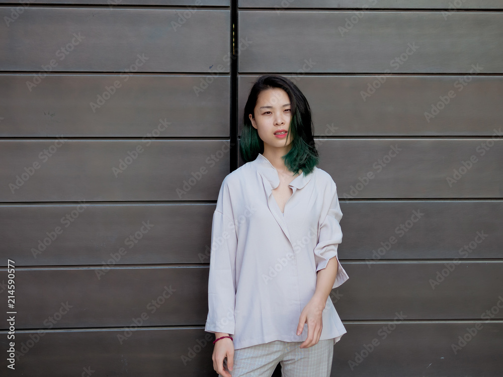 Beautiful young girl with green hair posing outdoor. Sunny portrait of glamour Chinese stylish lady. Emotions, people, beauty and lifestyle concept.