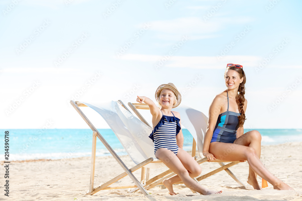 mother and daughter looking into the distance while sitting on beach chairs