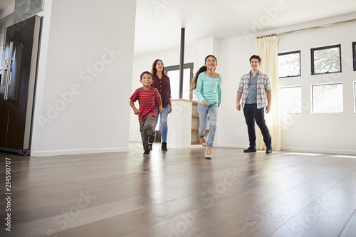 Excited Family Exploring New Home On Moving Day