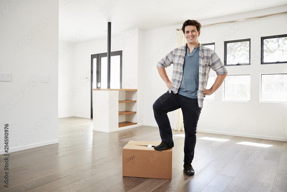 Portrait Of Proud Man Standing On Box In New Home On Moving Day Portrait Of Proud Man Standing On Box In New Home On Moving Day