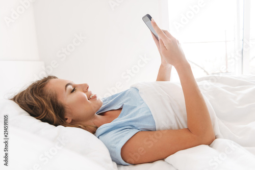 Happy young woman using mobile phone