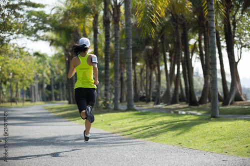 sporty young fitness woman running at tropical park