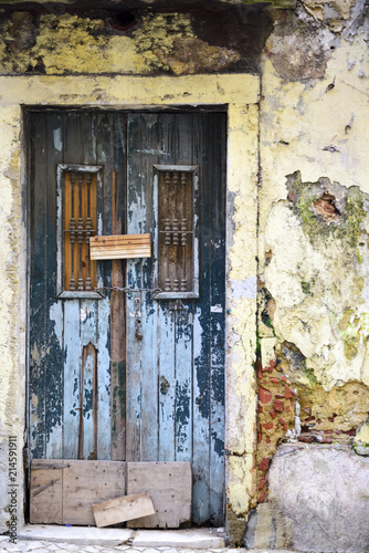 old wooden door on a ruined facade © Stefania