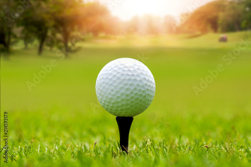 Golf ball on beautiful green grass with sunlight in morning time. Sport and recreation playground for golf club concept. 