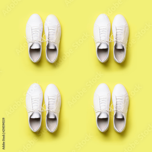 Stylish white sneakers and rope on yellow background with copy space. Top view. Square crop. Minimal flat lay. Summer shoes collection. First step concept