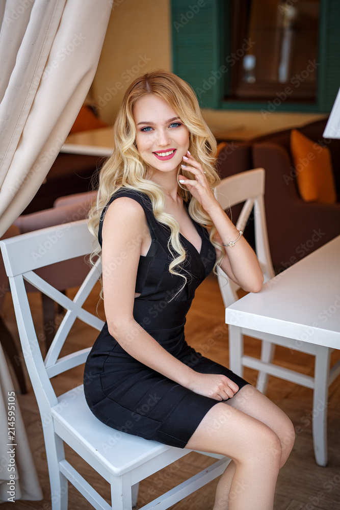 Beautiful blonde girl in a black sexy dress Stock Photo | Adobe Stock