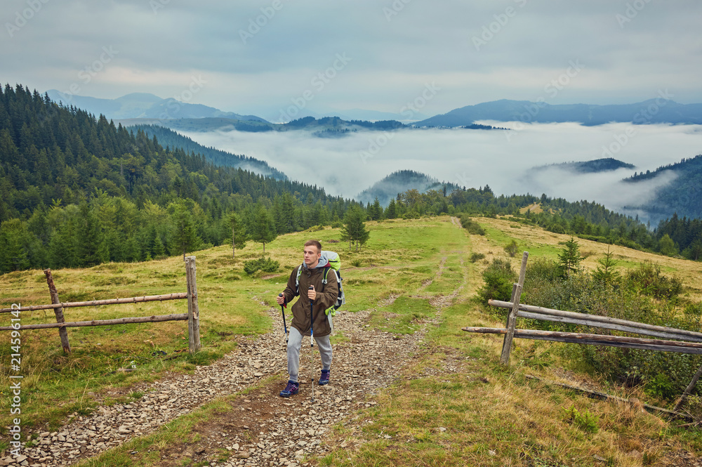 Man hiking at sunset mountains with heavy backpack Man hiking at sunset mountains with heavy backpack