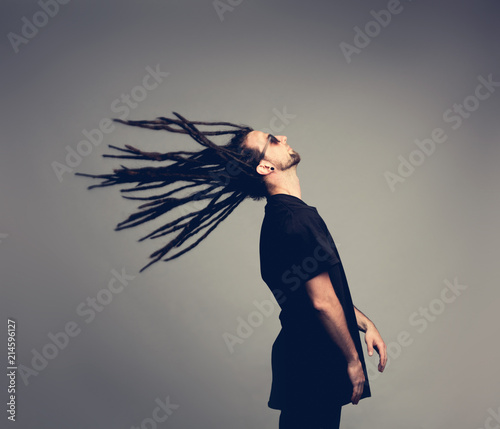 Canvas-taulu Young man flipping his dreadlocks back.