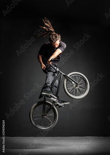 A man doing an extreme stunt on his BMX bicycle.