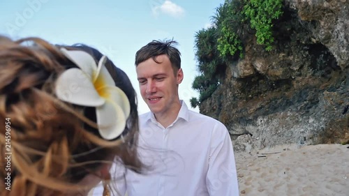 Portrait of Bride Holds Wedding Bouquet and Groom at Background