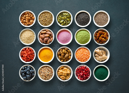Various colorful superfoods in bowls on dark background photo