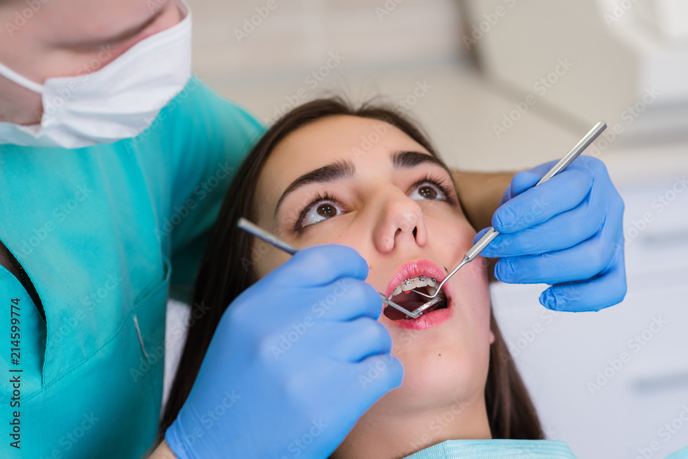 Close up of a dentist hand showing an implant to a patient in an office Close up of a dentist hand showing an implant to a patient in an office
