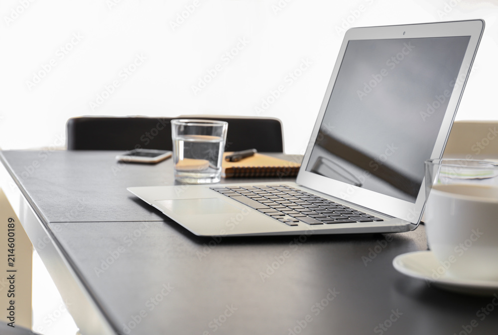 Table with laptop prepared for business meeting in conference hall Table with laptop prepared for business meeting in conference hall