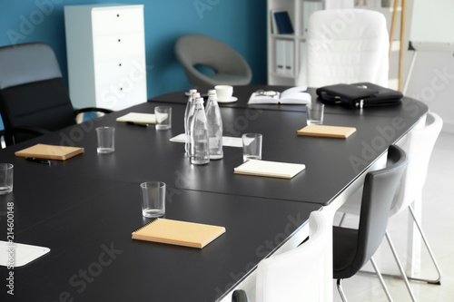 Table with notebooks prepared for business meeting in conference hall