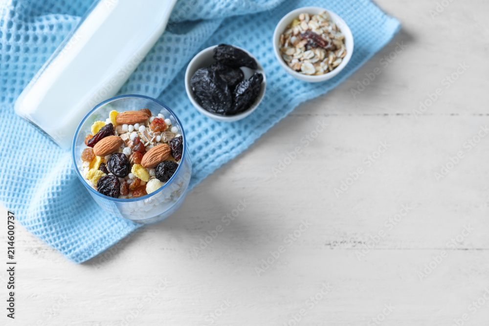Tasty oatmeal dessert with almonds and dried fruits in glass on light background Tasty oatmeal dessert with almonds and dried fruits in glass on light background