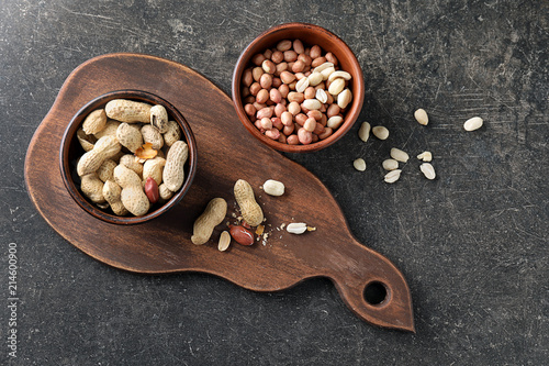 Bowls with tasty peanuts on table