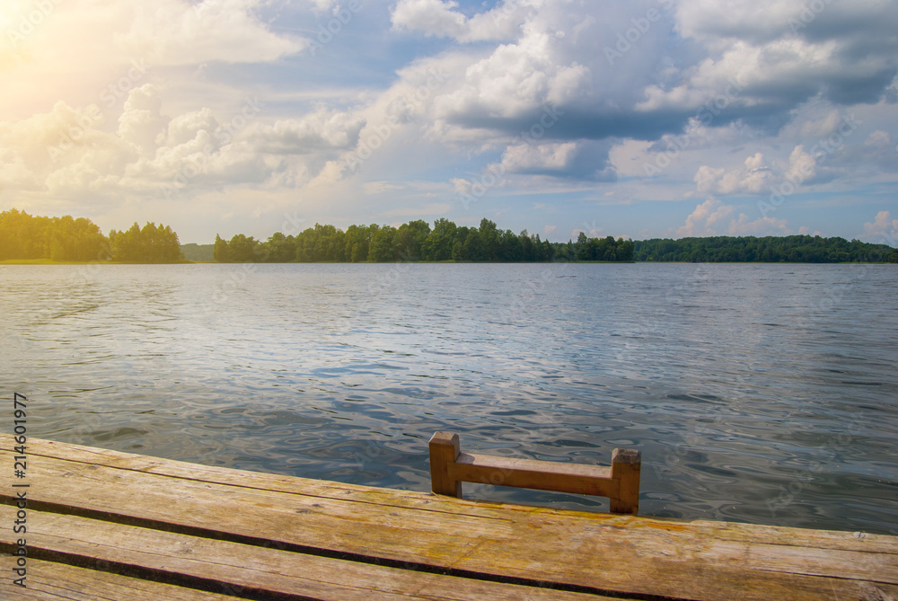 Summer Wooden Pier with stairway on the Lake at sunny day with a blue clouds