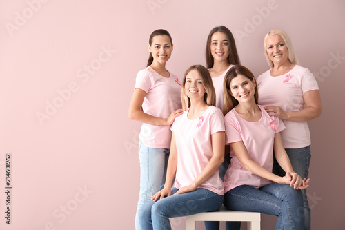 Beautiful women of different ages with pink ribbons on color background. Breast cancer concept photo