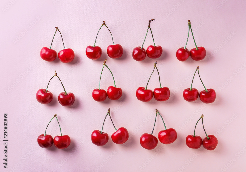 Flat lay composition with ripe cherries on color background