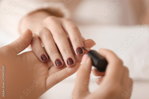 Young woman getting professional manicure in beauty salon