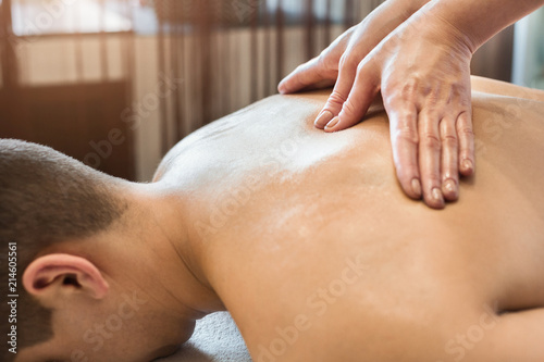 Close-up of masseur's hands and a client's back