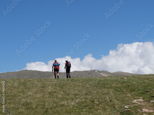 Couple marchant en montagne sur fond de ciel