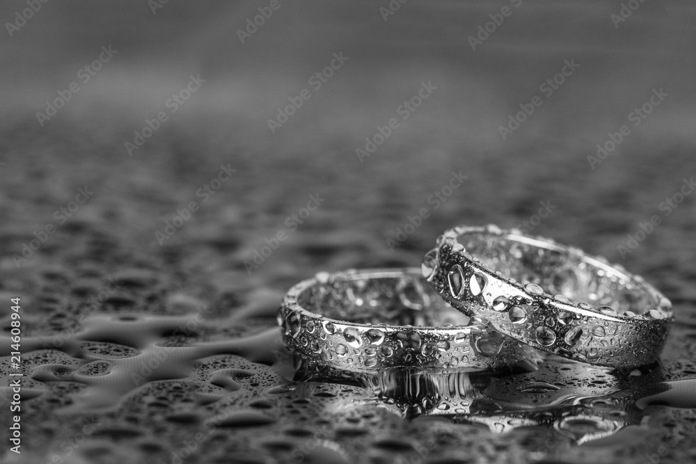 Wedding rings with water drops on grey background with copy space. Wedding rings with water drops on grey background with copy space.
