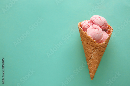 Canvas-taulu Waffle cone with delicious strawberry ice-cream on color background