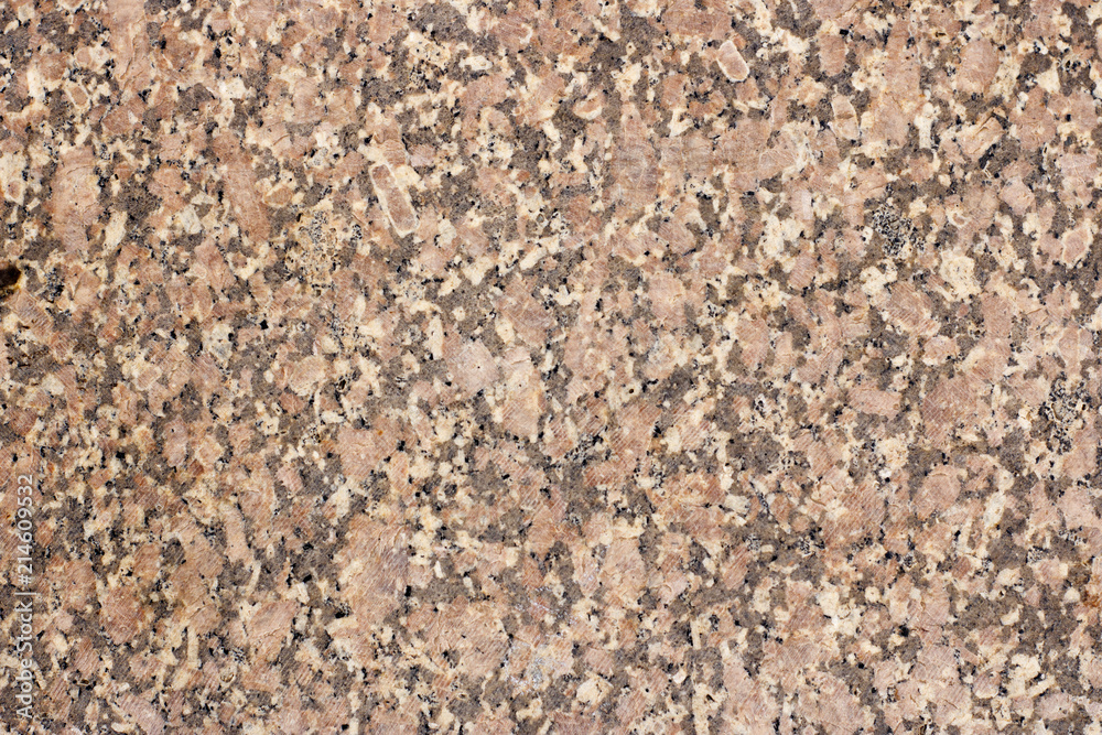 The texture of a spotted granite slab of orange color The texture of a spotted granite slab of orange color