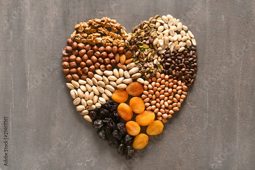 Fototapeta Naklejka Na Ścianę i Meble -  Heart made of different nuts and dried fruits on grey background