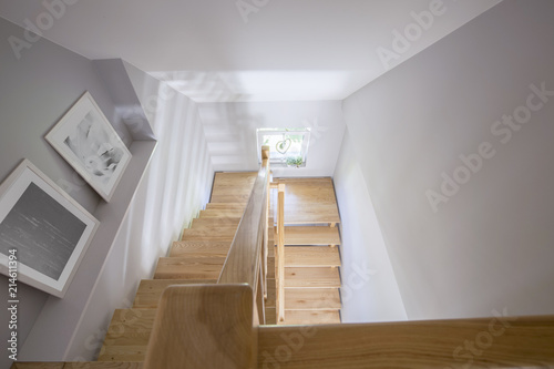 High angle on posters and wooden stairs in the hall of house int