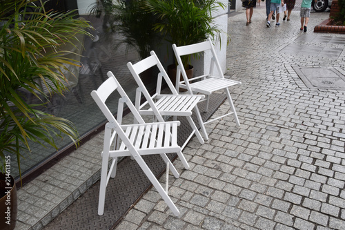 three white chairs on the street