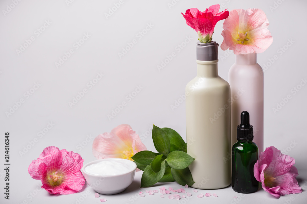 Natural Cosmetics set and flowers on gray background Natural Cosmetics set and flowers on gray background