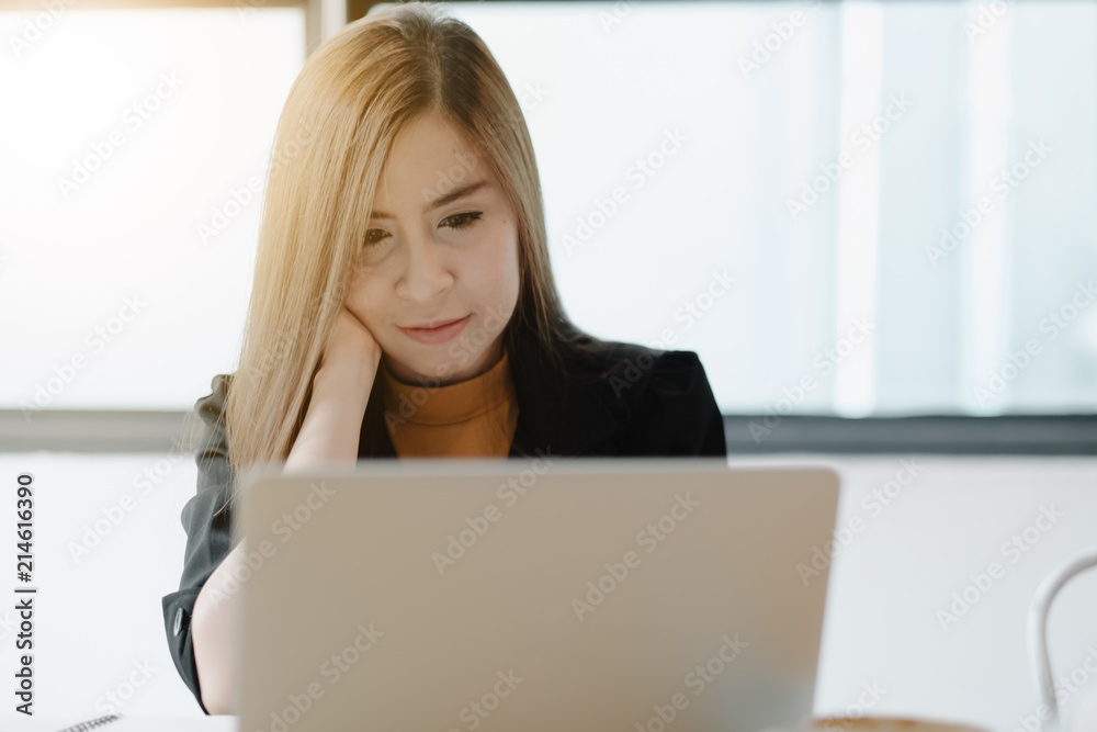 Young woman sitting in coffee shop at wooden table, drinking coffee and using laptop.On table is laptop. Girl browsing internet, chatting, blogging. Female holding laptop and looking on his screen. Young woman sitting in coffee shop at wooden table, drinking coffee and using laptop.On table is laptop. Girl browsing internet, chatting, blogging. Female holding laptop and looking on his screen.