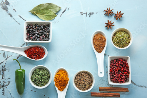 Composition with different dry spices on color background