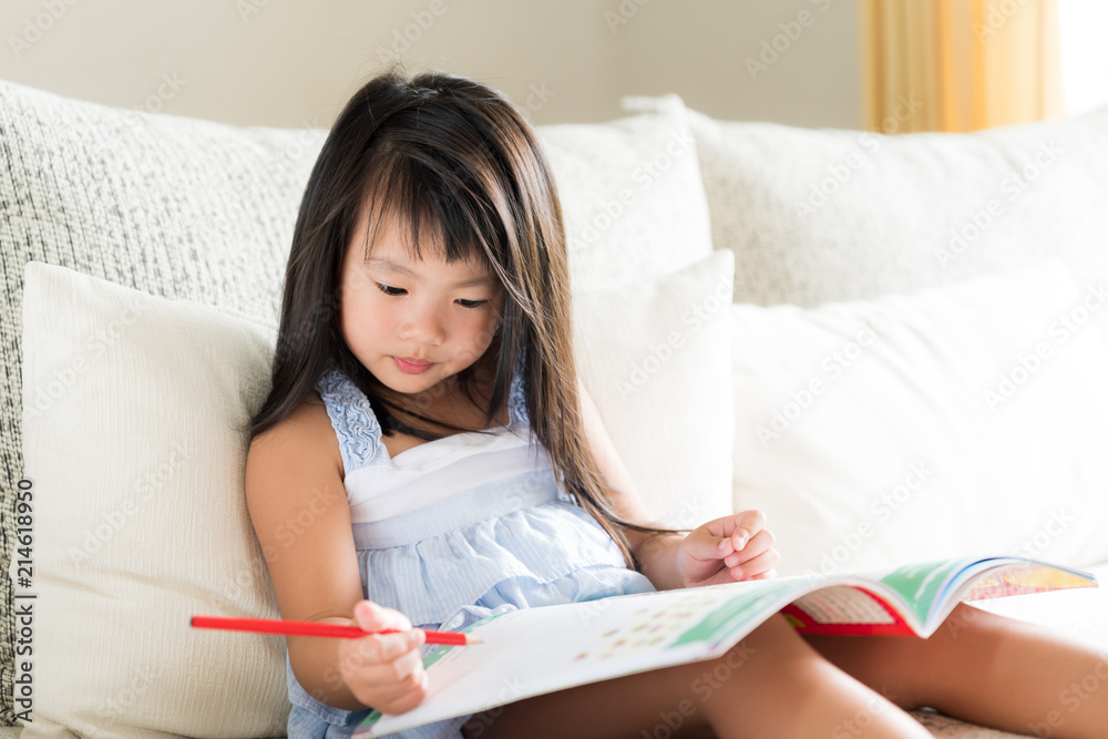 Happy cute little girl smiling and holding red pencil and drawing, writing on a book to do homework. kid education concept. Happy cute little girl smiling and holding red pencil and drawing, writing on a book to do homework. kid education concept.